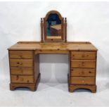 A 20th century pine dressing table of eight drawers, to bracket feet, a bedside cabinet with