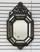 Dutch-style embossed metal antique wall mirror with ornate shell and pierced scroll pediment, the