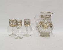 Late Victorian/Edwardian cut glass gilt jug faceted body floral and festoon decorated and three