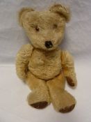 Small blonde straw stuffed bear with glass eyes and stitched nose and mouth 35cm