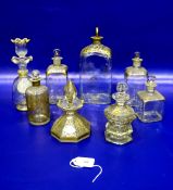 Four gilt glass bottles having gilt decorated shoulders and stoppers, various sizes; a gilt