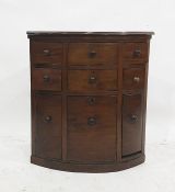 A late 19th century mahogany corner cabinet with six assorted drawers above three cupboard doors,