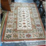 Cream ground Kazak type rug with eight central diamond-shaped medallions, on a stepped border, in