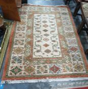 Cream ground Kazak type rug with eight central diamond-shaped medallions, on a stepped border, in