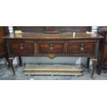 An 18th century and later North Country oak dresser base with three cross banded drawers and the