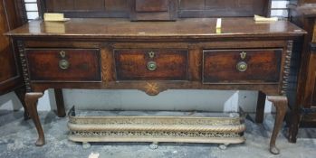 An 18th century and later North Country oak dresser base with three cross banded drawers and the