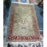 Eastern silk rug, the cream ground field with foliate decoration in vases, with large central blue