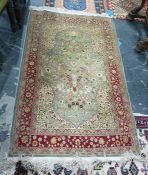 Eastern silk rug, the cream ground field with foliate decoration in vases, with large central blue