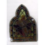 Antique stained glass arched window panel with armorial decoration; the shield decorated with