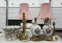 A pair of ceramic table lamps, on brass coloured metal bases painted with roses and gilt decoration,