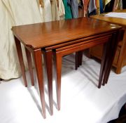 20th century teak nest of three coffee tables, the rectangular tops with indented corners, on square