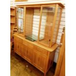 Modern light elm Ercol dresser, the shaped top above central open glass shelves flanked by glass