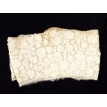 Early handmade tape lace backed onto muslin, featuring floral decoration, possibly cut from a skirt,