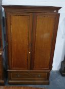 Edwardian mahogany crossbanded wardrobe enclosed by framed panelled doors, drawer below on plinth