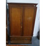 Edwardian mahogany crossbanded wardrobe enclosed by framed panelled doors, drawer below on plinth