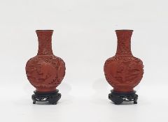 Pair of Chinese Cinnabar lacquer and blue enamel vases on wooden stands, carved with figures in