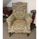 A early Victorian armchair with foliate loose fitting covers, on square section tapering supports,