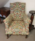A early Victorian armchair with foliate loose fitting covers, on square section tapering supports,
