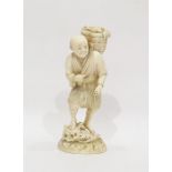 Japanese ivory okimono, late 19th century, modelled as a fisherman carrying a basket of fish over