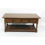 Modern oak rectangular coffee table over two drawers, raised upon turned supports to block feet,