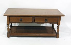 Modern oak rectangular coffee table over two drawers, raised upon turned supports to block feet,