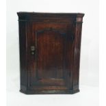 17th century oak wall hanging corner cupboard, panelled door flanked fluted canted