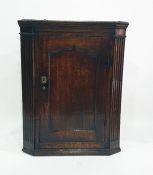 17th century oak wall hanging corner cupboard, panelled door flanked fluted canted