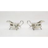Pair of George V silver sauce boats with reeded borders, scroll handles, raised on cabriole legs
