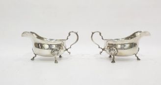 Pair of George V silver sauce boats with reeded borders, scroll handles, raised on cabriole legs