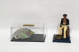 A fragment of the Berlin Wall (1961-1989) and a figure of a sailor seated on a barrel by United