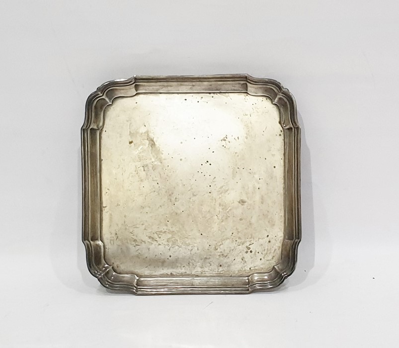 George V square silver salver with reeded wavy edged border, raised on pad feet, Chester 1923,