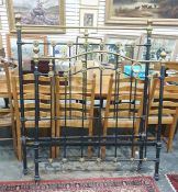 A iron & brass four foot bed frame raised upon brown china castors