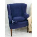 Blue ground wing back armchair on square section tapering supports to brass castors