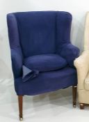 Blue ground wing back armchair on square section tapering supports to brass castors