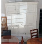 White painted pine cupboard, the ogee moulded cornice above three door top box, three wardrobe