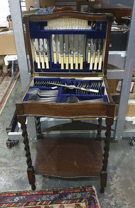 A near complete 6 place canteen of cutlery, cased in an oak side table on barley twist legs with