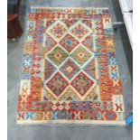Cream ground rug with blue, green and red diamond pattern to central field on stepped border 140