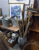 Galvanised milk churn and bath containing a selection of vintage tools, including rakes, hoes,