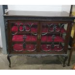 A 19th century mahogany display cabinet, the moulded edge above carved frieze, glazed doors