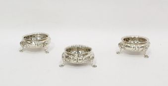 Set of three Victorian silver salts with embossed foliate decoration, raised upon four paw feet