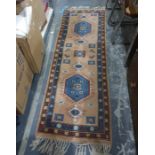 Wool rug of geometric design in blue and pink  218 x 74 cms