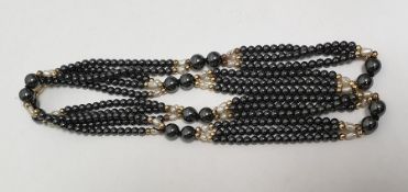 String of hematite beads with baroque pearl and gold-coloured beads