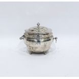 George V silver tea caddy of circular bulbous form with hinged cover and ring handles, raised on pad