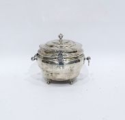 George V silver tea caddy of circular bulbous form with hinged cover and ring handles, raised on pad