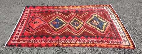 Eastern rug, red ground with four stepped lozenge shaped medallians in red, oranges, blues and pinks