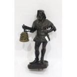Metal figure of a man, modelled standing with his hand on his hip, holding a bell, dressed in the