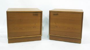 A pair of teak single door bedside cabinets raised on plinth bases, each 56 x 55.5cm (2)