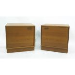 A pair of teak single door bedside cabinets raised on plinth bases, each 56 x 55.5cm (2)