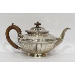 Victorian silver teapot of compressed form with repousse garland decoration and reeded body, on a
