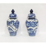 Pair of Asian porcelain blue and white oviform vases and domed covers, moulded in relief with
